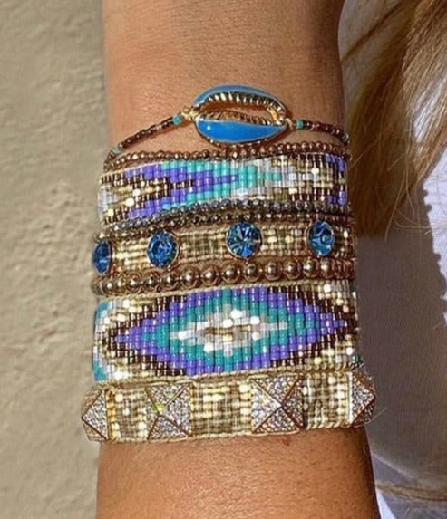 A group of six different bracelets, in blue, purple, gold and white. Offered as a set .