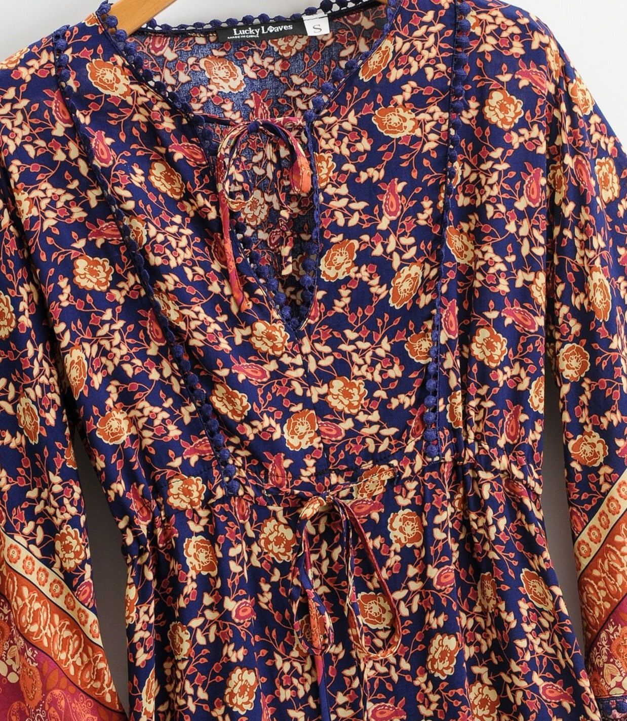 Midi length Rayon dress in dark blue with orange pattern flowers overall.